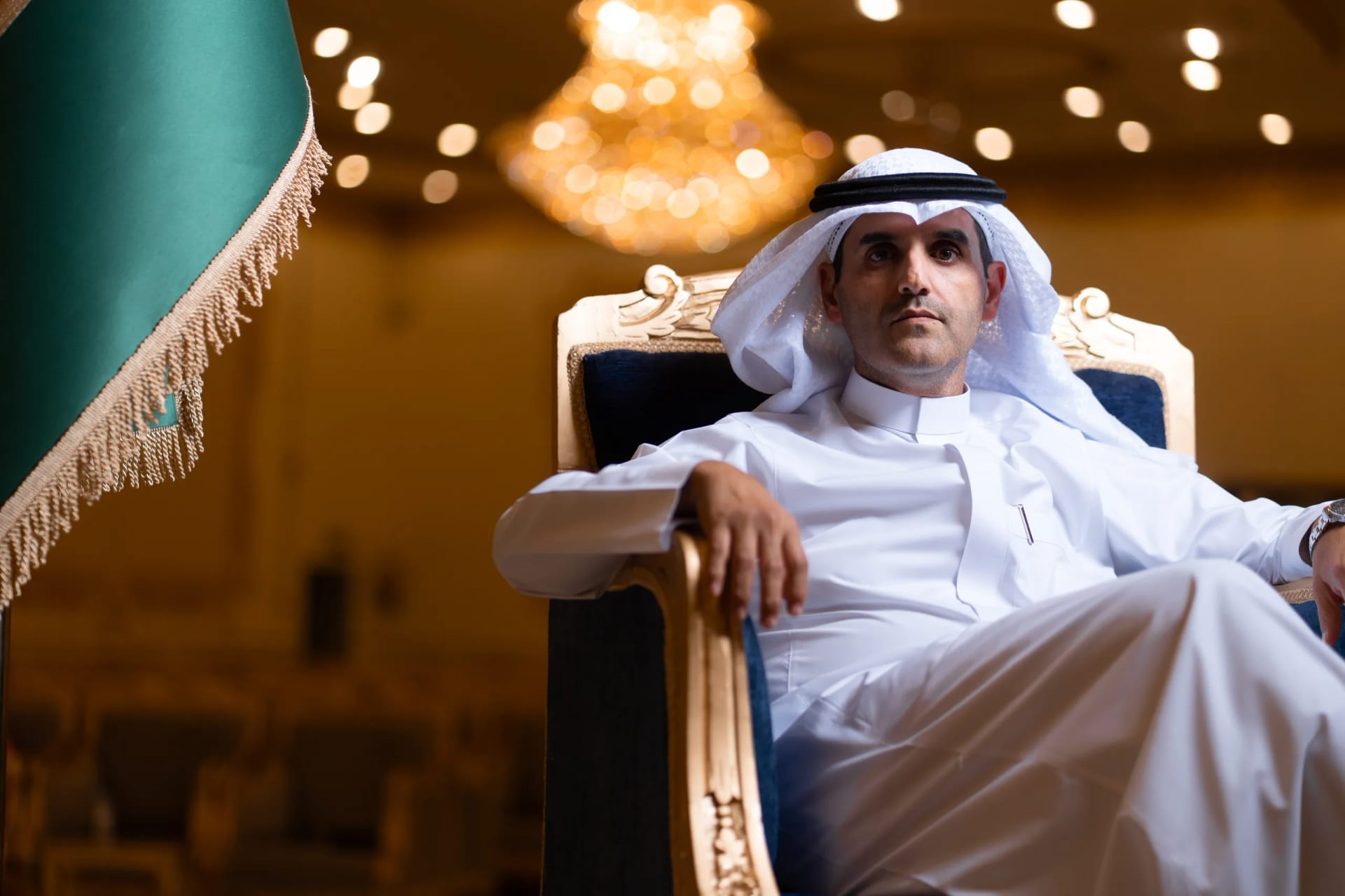 Formal seated portrait with the Saudi flag